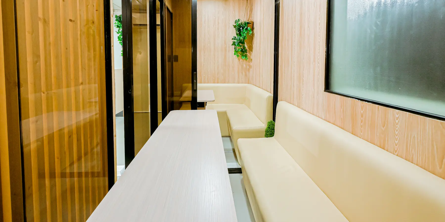 Viranova collaborative suite with meeting table, bench seating and glass partitions